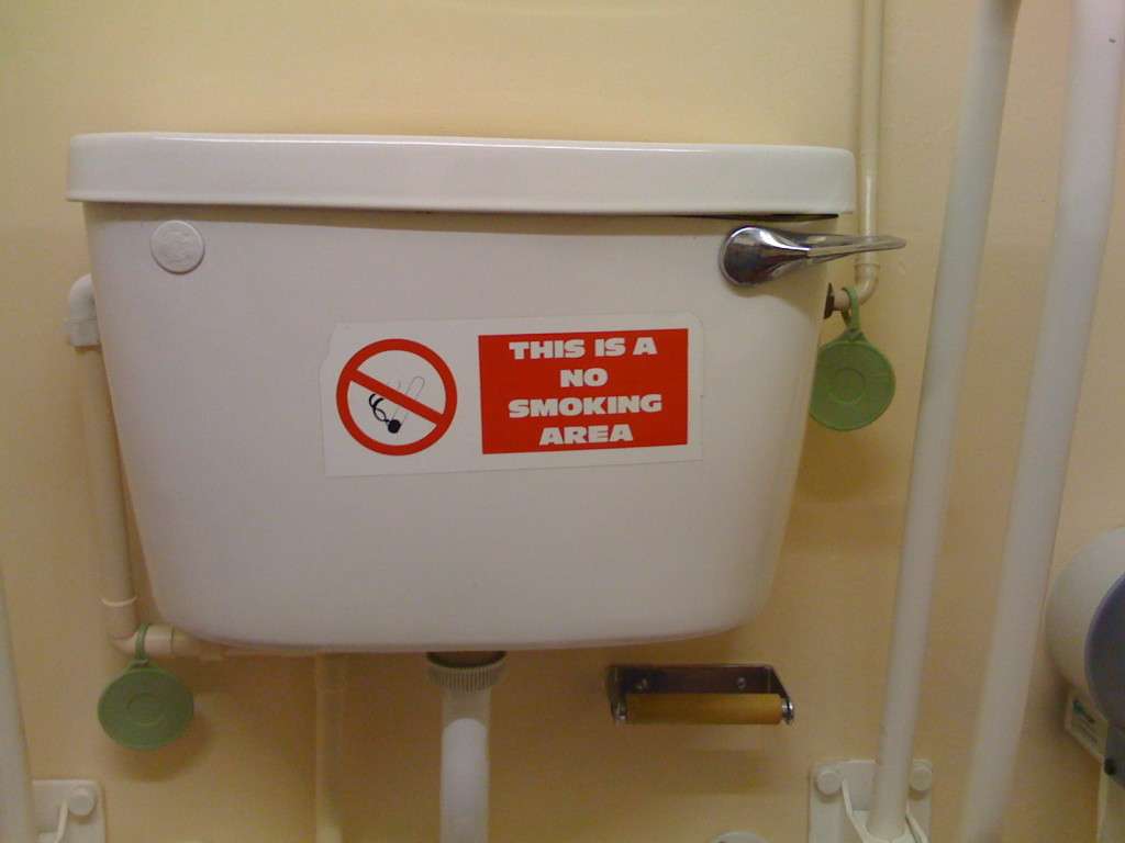 Sign reads: No smoking and is placed on a toilet cistern