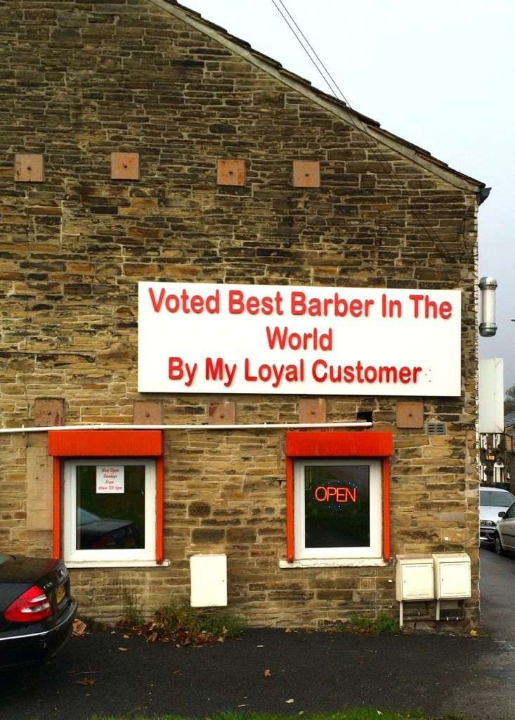 A sign which reads 'voted best barber in the world by my loyal customer'